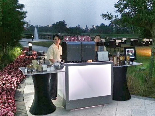 Barista serving espresso at a branded booth
