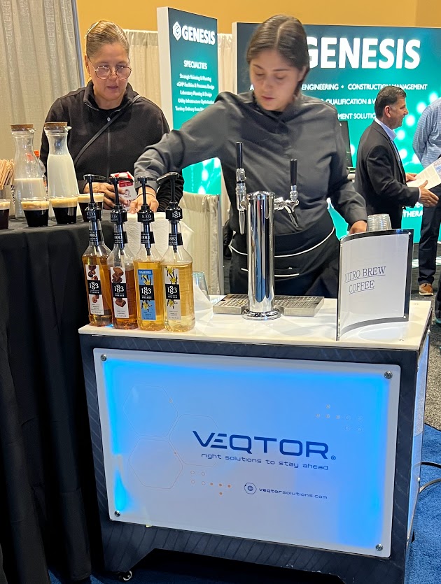 Professional barista serving espresso at a trade show booth